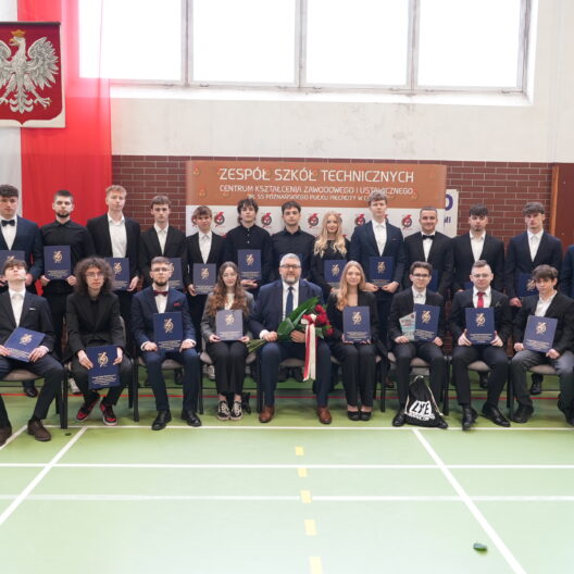 Group of Students in Suits Posing for a Formal Graduation Photo in a School Gym Holding Blue Diplomas 9 Września 2025 Dsc00473