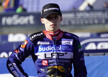 ML3429 Portrait of a Motorcycle Racer in a Navy Blue Racing Suit with Sponsor Patches and a Black Cap at a Race Track Finish Area 14 Maja 2023 ml 3429