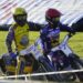 Two Speedway Riders in Yellow and Purple Racing Suits Lean into a Turn on a Dirt Track with Grass in the Background 15 Czerwca 2020 
