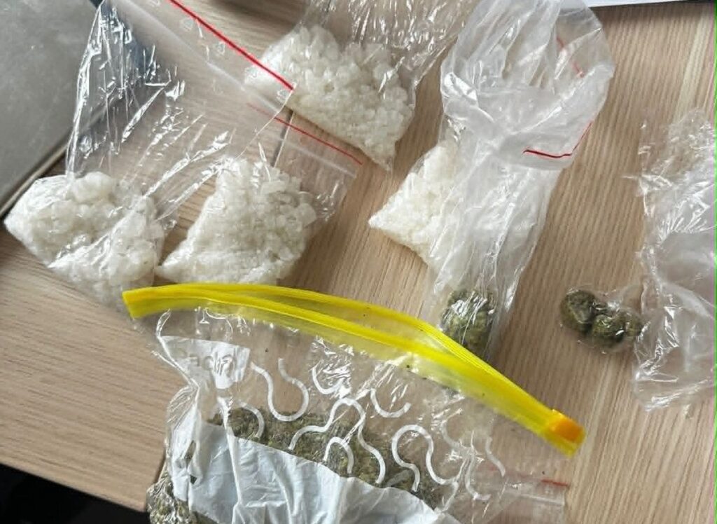 Several Clear Bags Contain White Crystalline Substance on a Wooden Surface with a Few Coins Nearby 9 Września 2025 