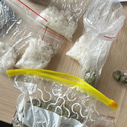 Several Clear Bags Contain White Crystalline Substance on a Wooden Surface with a Few Coins Nearby 9 Września 2025 