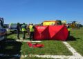 Emergency Responders Set Up a Bright Red Tent Labeled straŻ on a Grassy Field with Ambulances and a Yellow Helicopter in the Background 13 Czerwca 2020 
