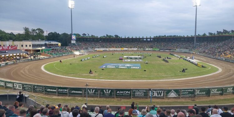 Crowded Outdoor Stadium with a Dirt Race Track Curved Turns and Tall Floodlights Overhead 31 Maja 2026