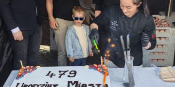 Child Wearing Blue Sunglasses Watches As a Chef in Black Oversees a Flaming Dessert Cake Decorated with Strawberries and Blueberries at a City Birthday Event 14 Czerwca 2020