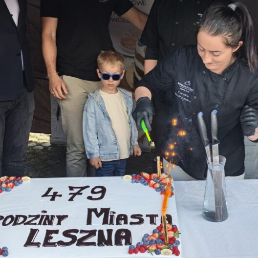 Child Wearing Blue Sunglasses Watches As a Chef in Black Oversees a Flaming Dessert Cake Decorated with Strawberries and Blueberries at a City Birthday Event 9 Września 2025 