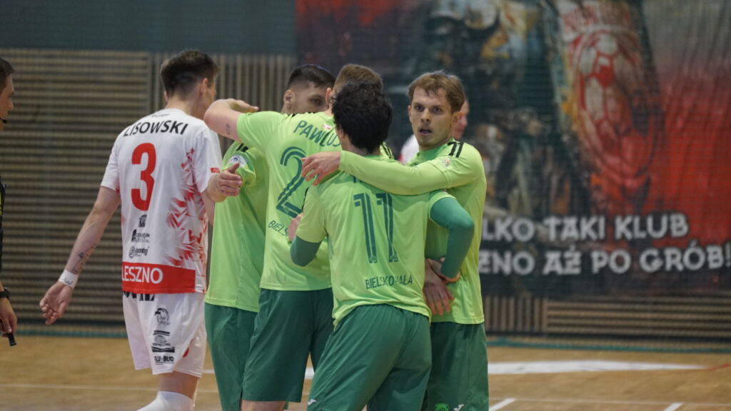 Team of Players in Lime Green Uniforms Hug on an Indoor Court Celebrating During a Match White Jersey with Number 3 Visible on Left 9 Września 2025
