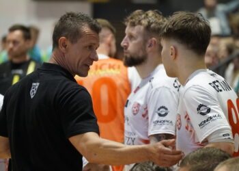 Coach in Black Shirt Shaking Hands with Athletes Wearing White Jerseys After a Game in a Crowded Indoor Venue 13 Lipca 2019