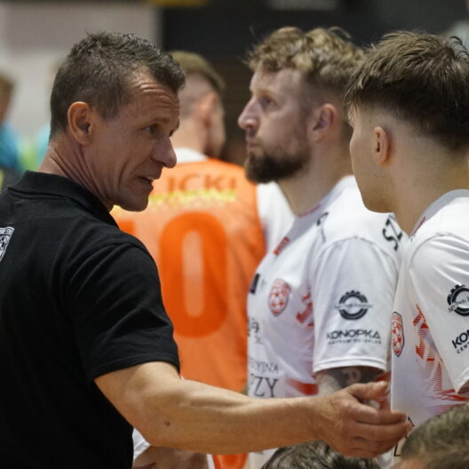 Coach in Black Shirt Shaking Hands with Athletes Wearing White Jerseys After a Game in a Crowded Indoor Venue 9 Września 2025