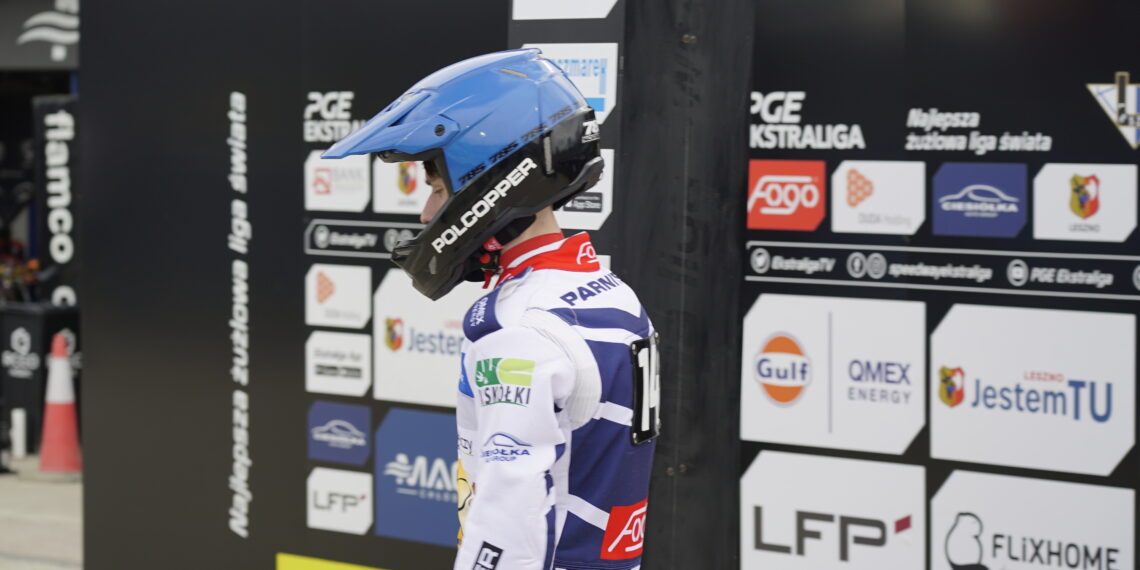 Motorsport Rider in a Blue Helmet and White Racing Suit Stands at a Sponsor filled Pit Wall 16 Czerwca 2020  ml 5067