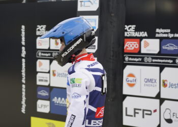 Motorsport Rider in a Blue Helmet and White Racing Suit Stands at a Sponsor filled Pit Wall 28 Kwietnia 2022  ml 5067