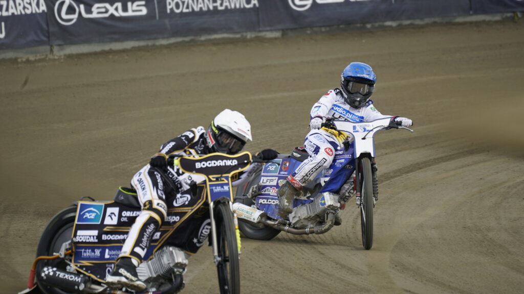 Two Speedway Riders Lean into a Dirt track Corner Kicking Up Dust with Sponsor Banners in the Background 9 Września 2025  ml 5151