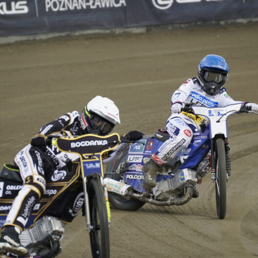Two Speedway Riders Lean into a Dirt track Corner Kicking Up Dust with Sponsor Banners in the Background 9 Września 2025  ml 5151