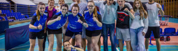 a Group of Athletes and Coaches Posing for a Team Photo in an Indoor Sports Hall Many Raising Fists and Smiling 8 Czerwca 2026